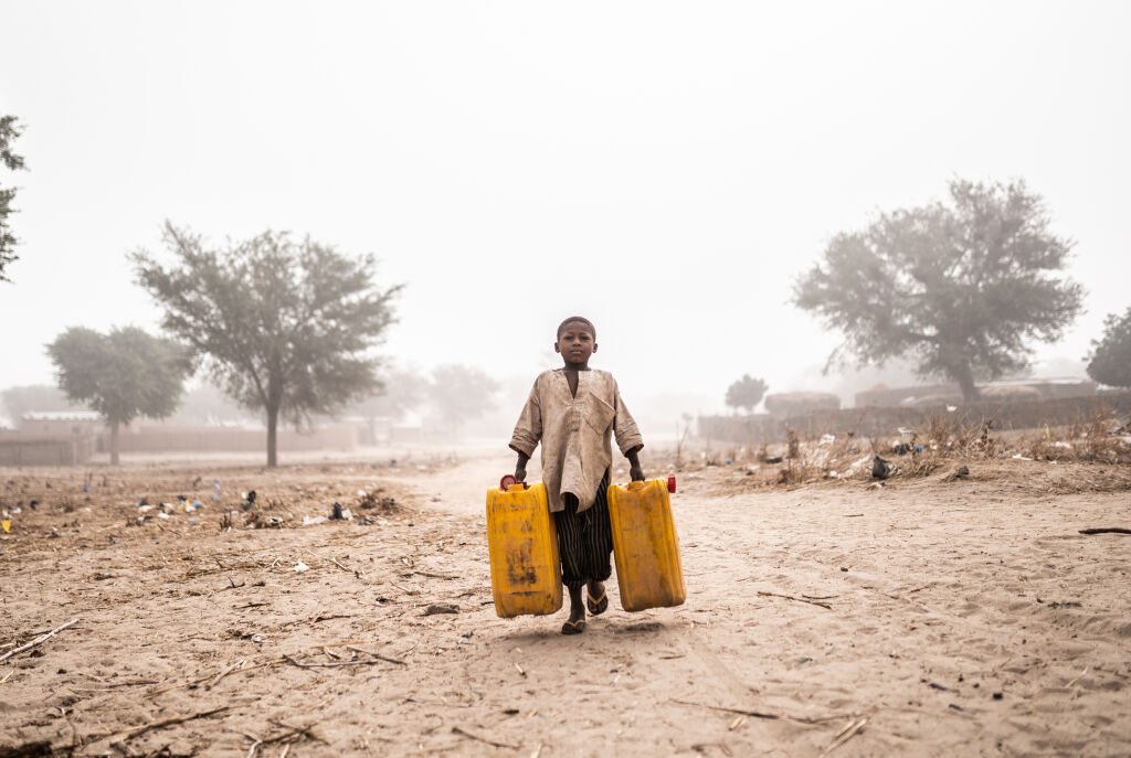 Poika kantaa vettä perheelleen pakolaisleirillä Nigerin Maradissa. Kuva: © UNICEF/UNI337865/Haro