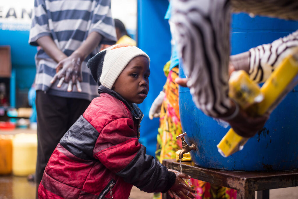 Pieni poika seuraa käsienpesuohjeistusta Kenian pääkaupungin Nairobin valtavalla Kiberan slummialueella. UNICEF tukee maata ehkäisemään koronaviruksen leviämistä. © UNICEF/UNI322682/Ilako