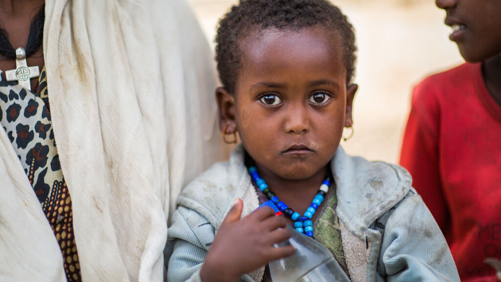 Miren, kolme vuotta, odottaa äitinsä kanssa puuroannosta Kilte Awlaelo Woredassa Etiopian Tigrayssa. Kuva: © UNICEF/UN024969/Sewunet.