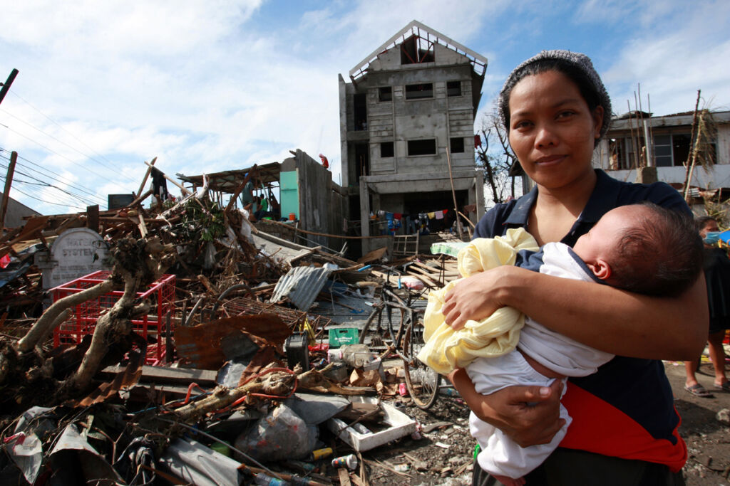 Nainen pitelee vauvaa supertaifuuni Haiyanin jälkeensä jättämän tuhon keskellä Taclobanin kaupungissa Filippiineillä. © UNICEF/NYHQ2013-1027/Maitem