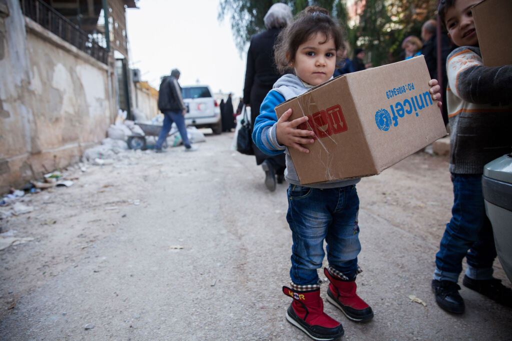 Syyrialainen maan sisäisessä paossa oleva lapsi sai talvivaatepaketin UNICEFilta al-Waerin kaupunginosassa Homsissa. © UNICEF/Syyria 2017/Martti Penttilä