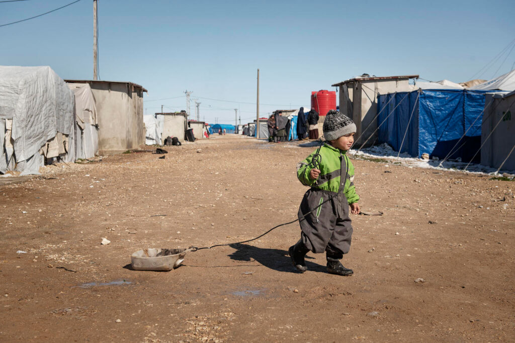 Pieni pakolaislapsi leikkii ometekoisella lelulla Pohjois-Syyriassa sijaitsevalla Rojin leirillä. Hän vetää perässään tyhjää vesikanisteria. © UNICEF/UNI310462/Romenzi