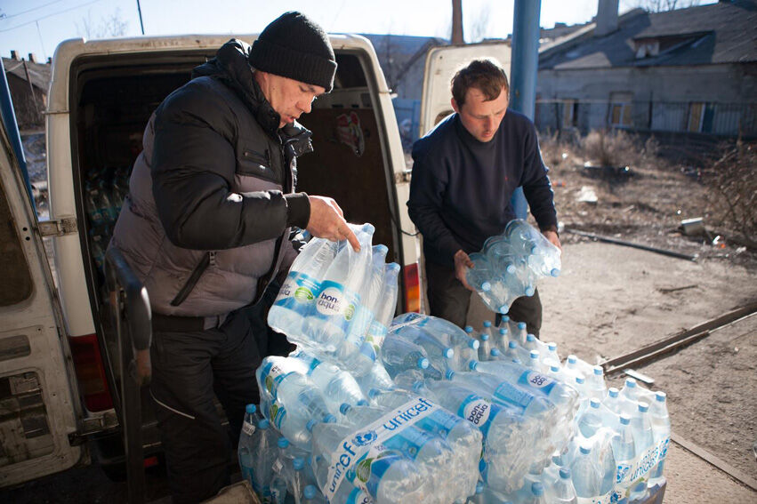 Vapaaehtoiset purkavat vesipullokuormaa Debaltsevon kaupungissa Donetskin alueella helmikuussa 2015. © UNICEF/NYHQ2015-0279/Filippov 