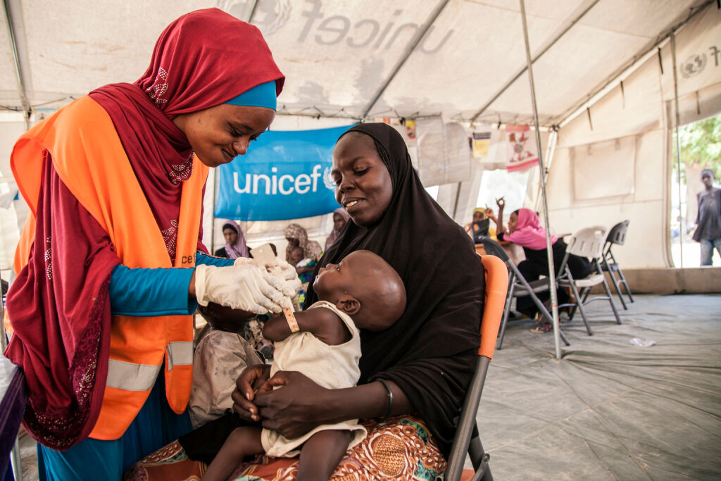 UNICEFin ravitsemusasiantuntija Aishat Abdullahi arvioi Umara Bukarin kuntoa. 7 kuukautinen Umara painoi vain 4,2 kiloa saapuessaan klinikalle Pohjois-Nigeriassa. Aliravittu lapsi sai apua klinikalla ja painaa nyt 5,1 kiloa. Kuva: UNICEF/Vittozzi   