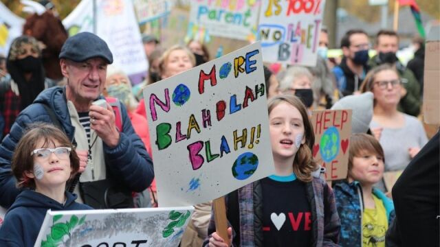 Nuori pitää mielenosoituksessa kylttiä, jossa lukee "no more blah, blah, blah"