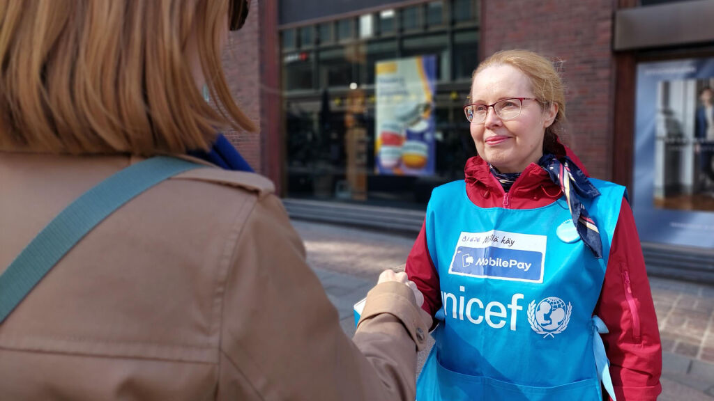 UNICEFin lipaskerääjä kohtaa asiakkaan.