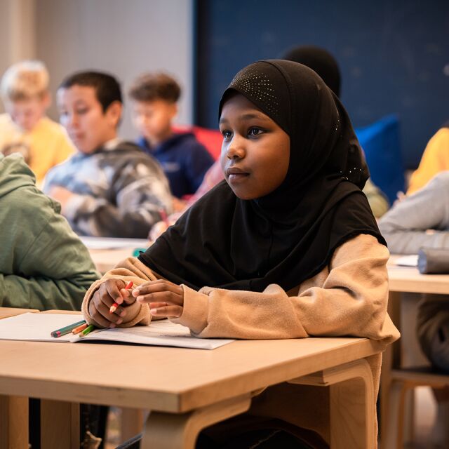 Koululaisia opiskelemassa koululuokassa.