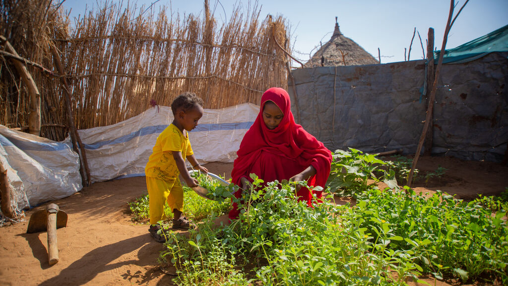 Äiti ja lapsi kasvimaalla Sudanissa. 