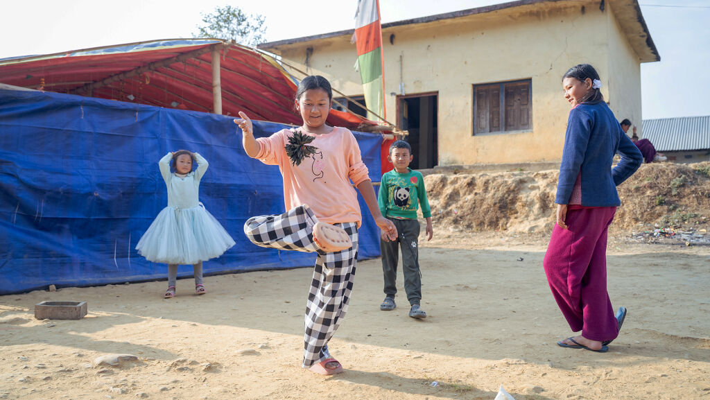 Lapset leikkivät UNICEFin lapsiystävällisen tilan edessä Nepalissa.