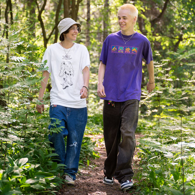 Kaksi teini-ikäistä lasta kävelyllä metsässä.