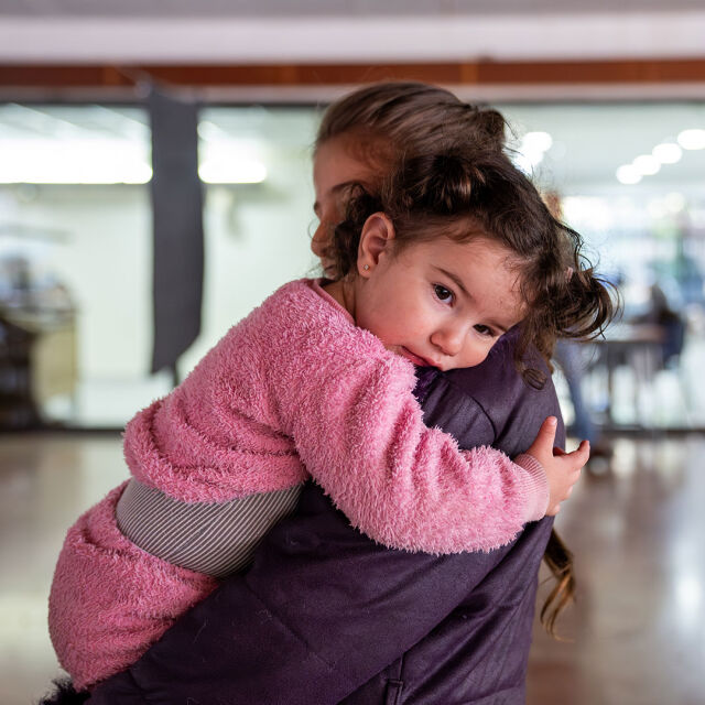 Lapsi siskonsa sylissä.