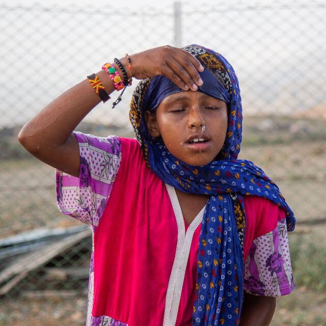 Lapsi kastelee kasvojaan vedellä.