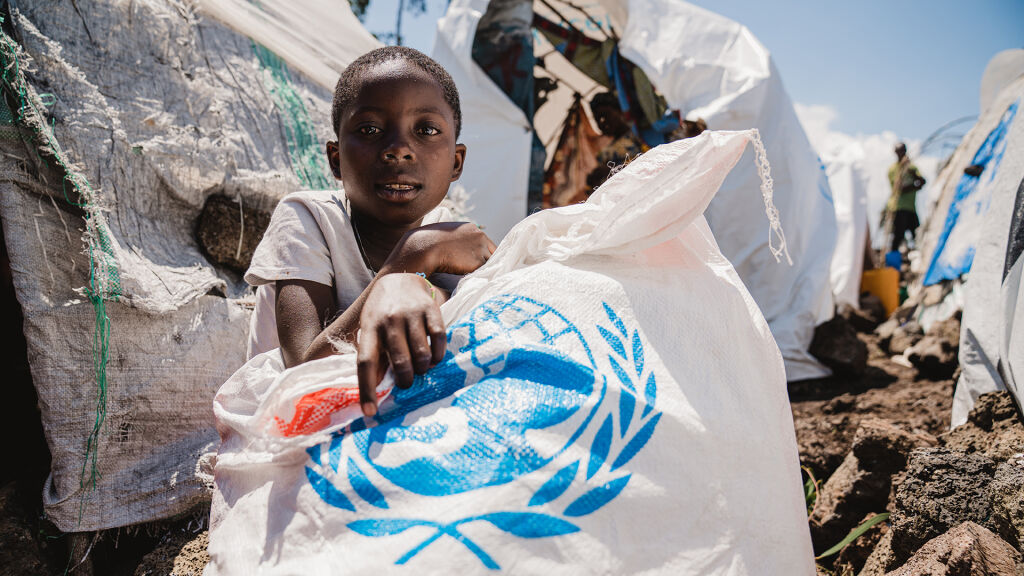 Lapsi UNICEFin ruokakassin kanssa.