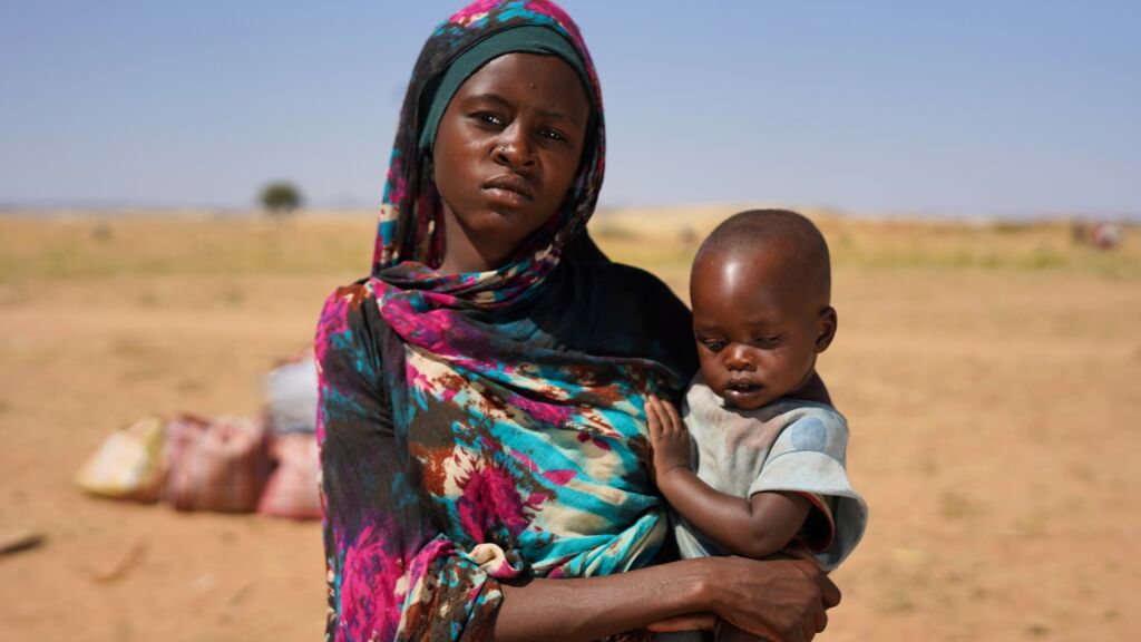 Nainen pitelee lasta sylissä.