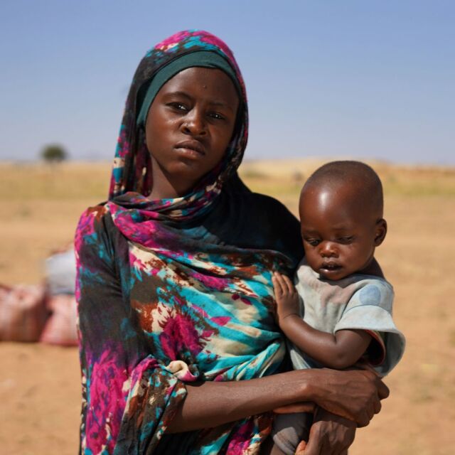 Nainen pitelee lasta sylissä.