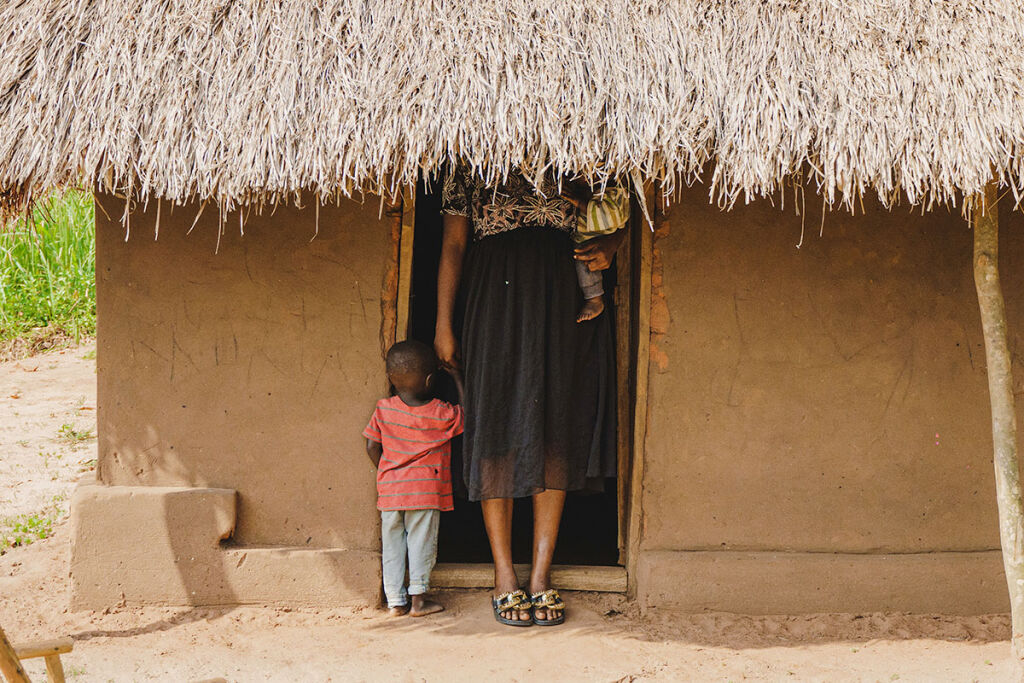 Äiti ja lapset talon edessä.