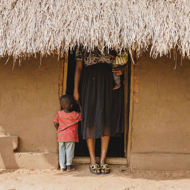 Äiti ja lapset talon edessä.