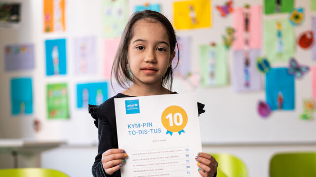 UNICEFin Kympin todistus sinisellä pohjalla.