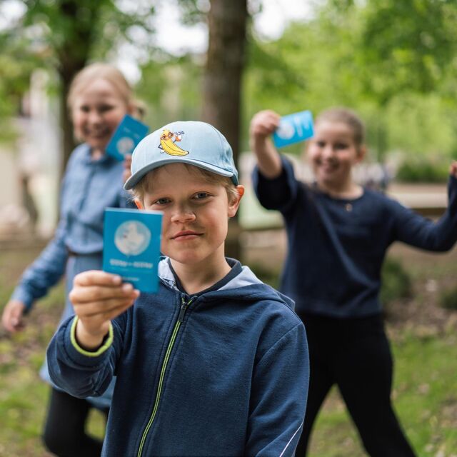 Vaaleanpunaiseen pörröasuun pukeutunut leikki-ikäinen lapsi isosiskonsa sylissä.