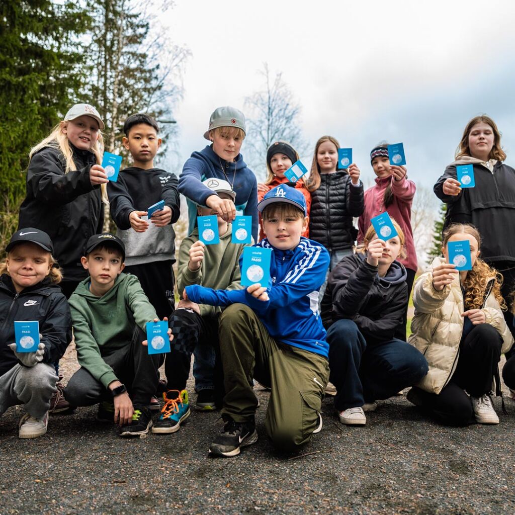 Lapsi esittelee UNICEF-kävelyn passia.