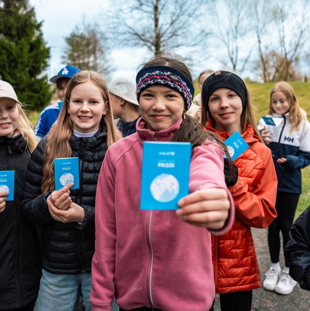 Lapsi esittelee UNICEF-kävelyn passia.