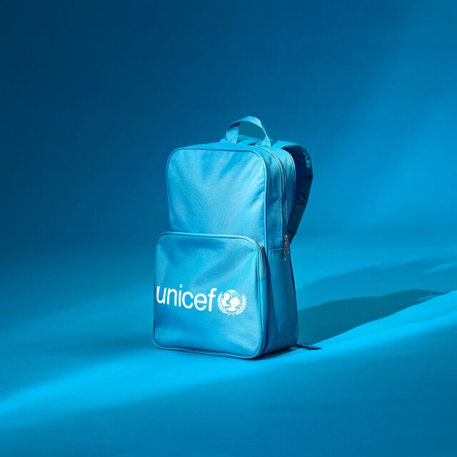 UNICEF-reppu sinisellä taustalla