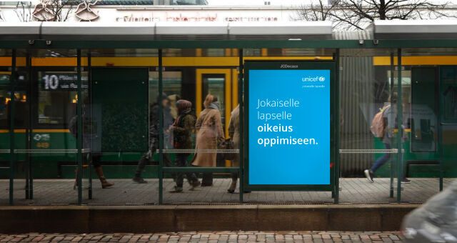 Raitiovaunupysäkki, jossa UNICEFin mainos, jossa lukee "jokaiselle lapselle oikeius oppimiseen."