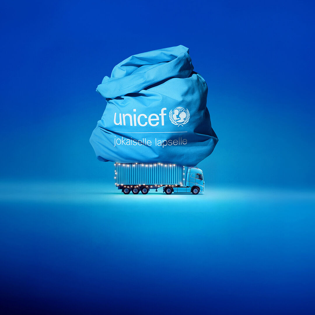 Kuva sinisestä rekasta, jonka päällä valtava lahjasäkki, jossa UNICEFin logo. 