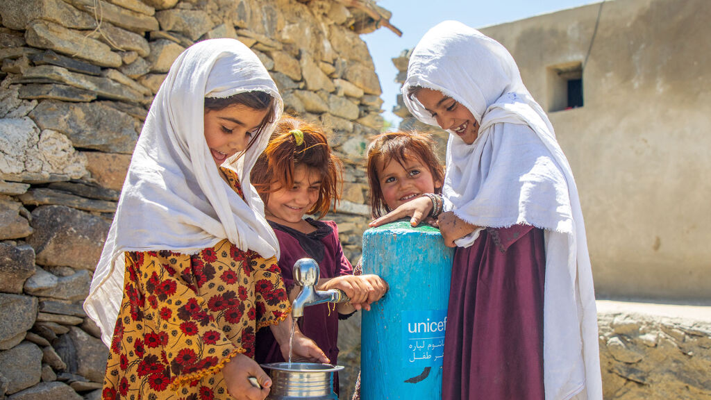 Neljä lasta hakee vettä UNICEFin rakentamalta kaivolta.