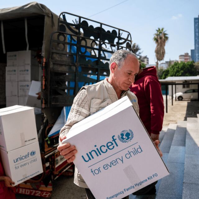 Ihmiset kantavat Libanonissa rekasta valkoisia laatikoita, joissa on UNICEFin logo. 