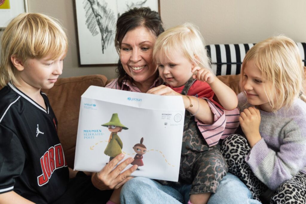 Anna Hanski lasten kanssa tutkimassa UNICEFin Muumien seikkailupostia.
