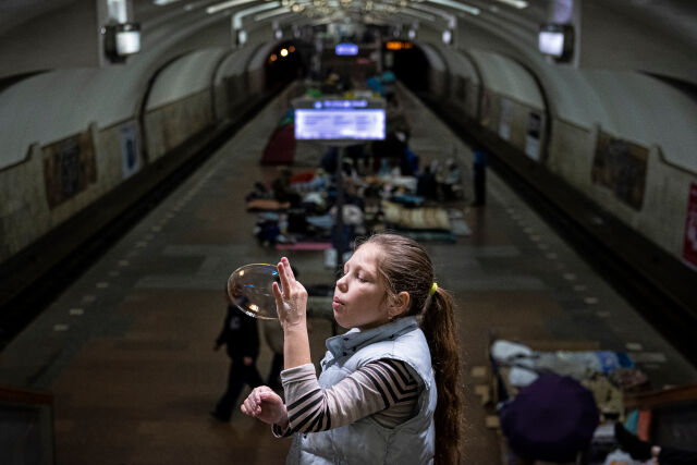 Ett barn blåser såpbubblor i den ukrainska tunnelbanan.