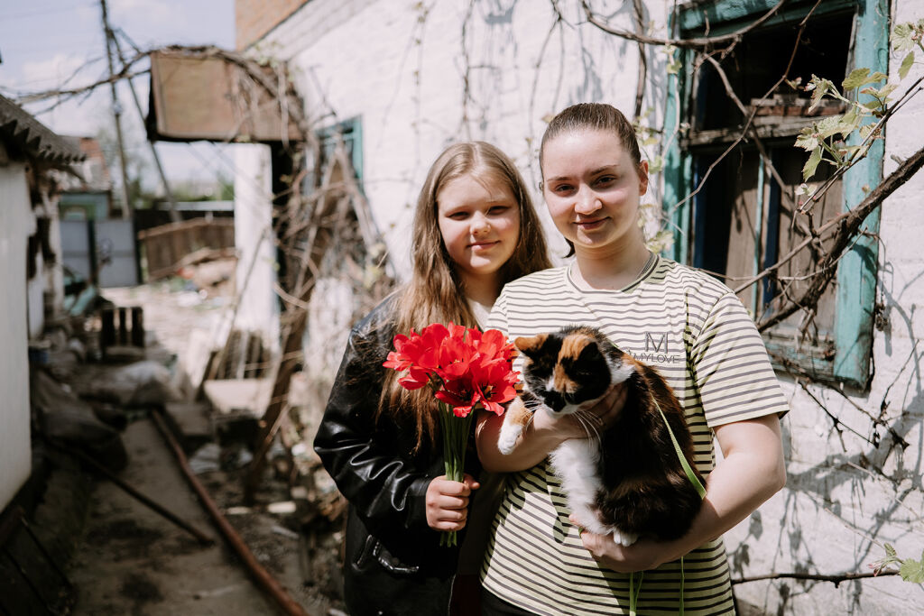 Ukrainalaiset sisarukset Ilona ja Daiana entisen kotitalonsa pihalla.