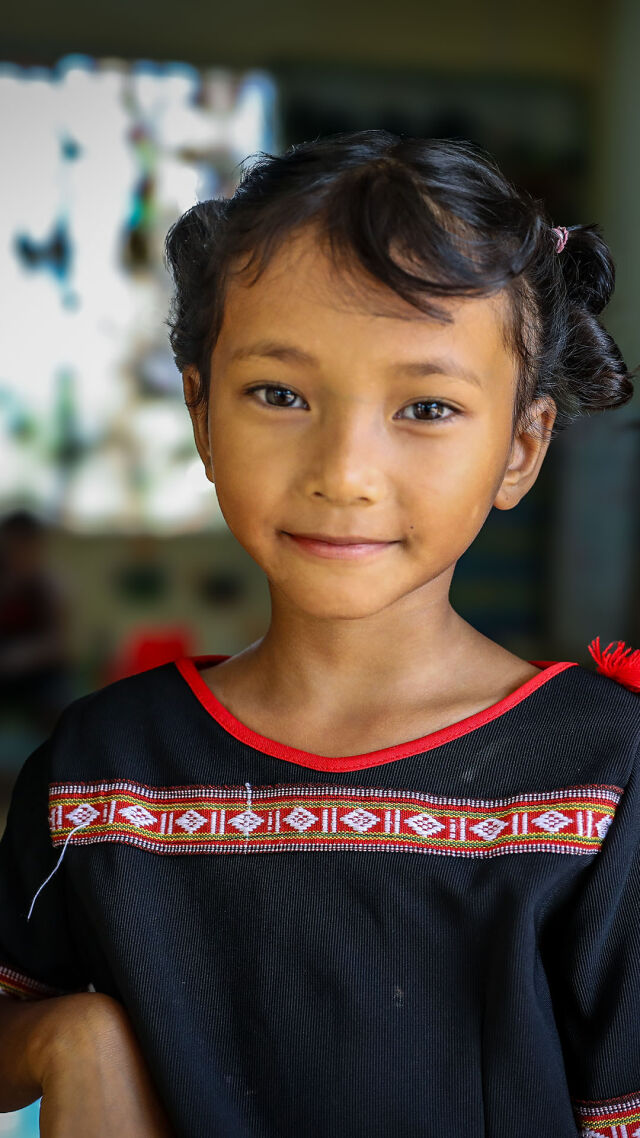 Kaksi tyttöä katsoo kameraan ja hymyilee. 