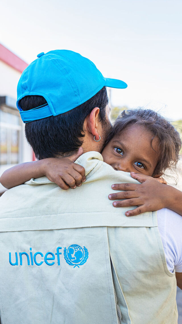 Unicefin työntekijä kantaa pientä lasta. 