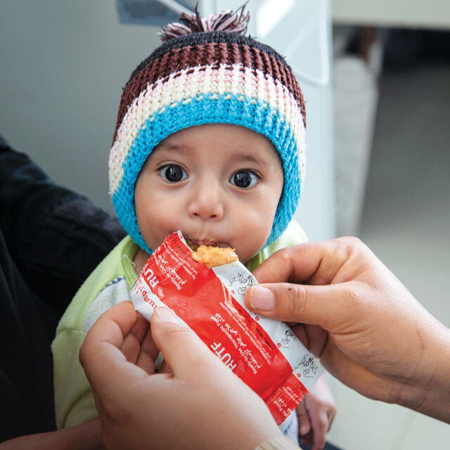 Lapselle syötetään maapähkinätahnaa suoraan pussista.