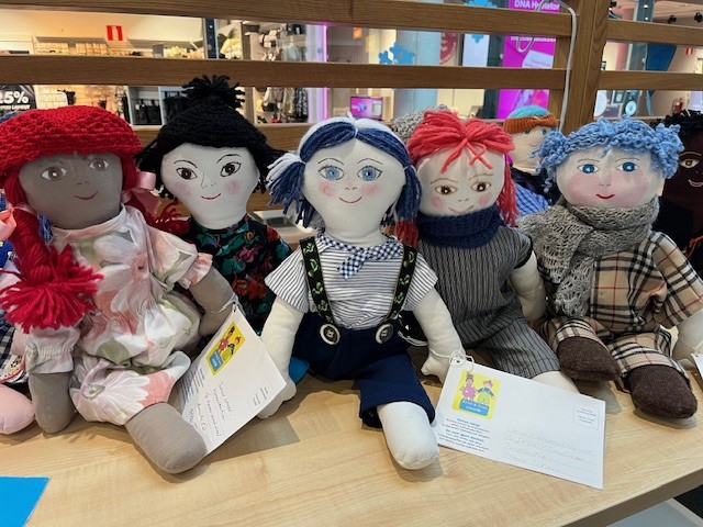 UNICEF-nukkeja rivissä pöydällä.