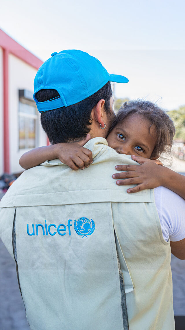 UNICEFin työntekijä kantaa lasta.