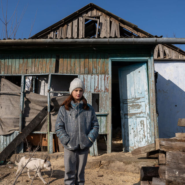 12-vuotias Alina seisoo pahoin vaurioituneen kotinsa edustalla Kobzartsin kylässä, Mykolaivissa Ukrainassa.
