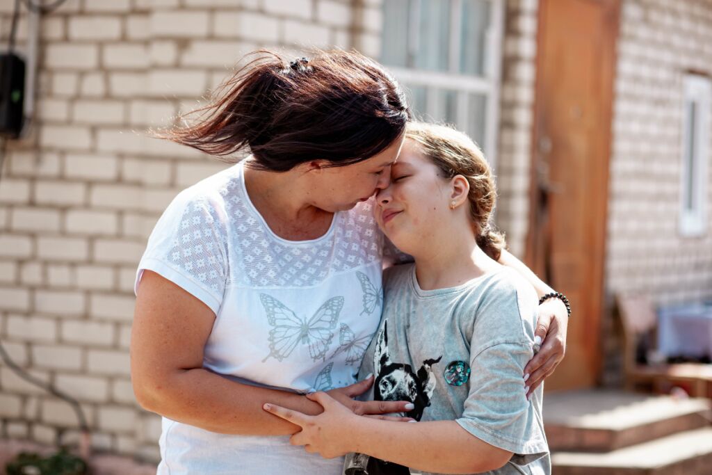 Yulia-äiti halaa 10-vuotiasta tytärtään Polinaa Hersonissa Ukrainassa